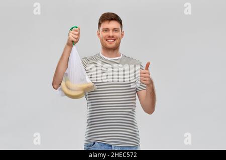 happy man holding reusable string bag with bananas Stock Photo