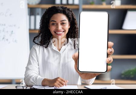 E-Learning Concept. Smiling Black Female Tutor Showing Big Blank Smartphone At Camera Stock Photo