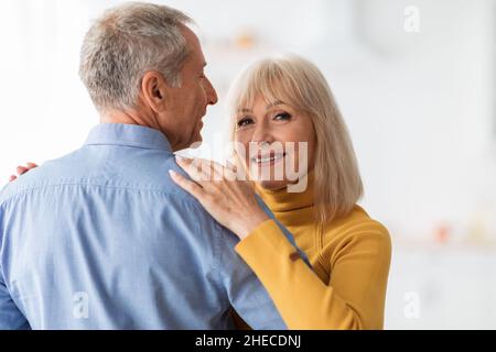 Senior Wife Dancing With Husband Smiling To Camera At Home Stock Photo