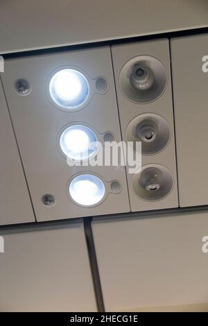 Passenger reading light array, lights switched on, and cool air nozzles / nozzle arrays / vents. Airbus A320 aircraft / air plane / aeroplane / airplane. (128) Stock Photo