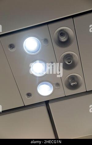 Passenger reading light array, lights switched on, and cool air nozzles / nozzle arrays / vents. Airbus A320 aircraft / air plane / aeroplane / airplane. (128) Stock Photo