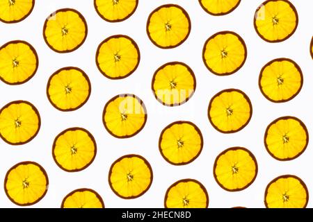 Pattern made of backlit orange slices on white background Stock Photo