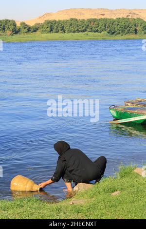 Egypt, Upper Egypt, Nile valley, Bassaw island (north of Kom Ombo), village woman filling a jar with water from the Nile Stock Photo