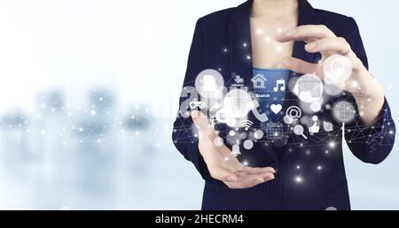 Social media or social network notification. Two hand holding virtual holographic social media icons with light blurred background. Communication and Stock Photo