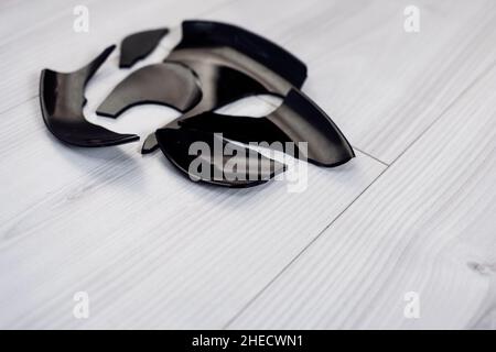 Splinters and fragments of the broken black ware. Metaphor of a family quarrel. Broken Plate. The concept of accidents in the kitchen. Stock Photo