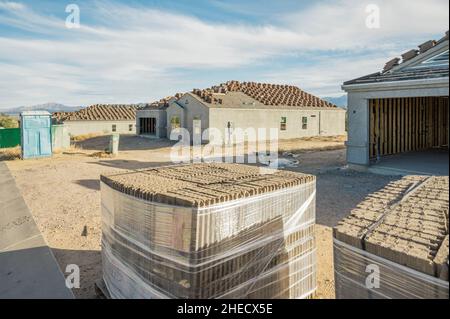 New home construction in with roof tiles in foreground Stock Photo