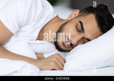Closeup Shot Of Handsome Young Arab Man Sleeping In Comfortable Bed Stock Photo