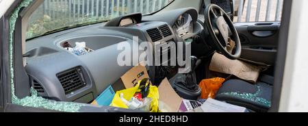 broken and smashed windows on van parked on the roadside Stock Photo