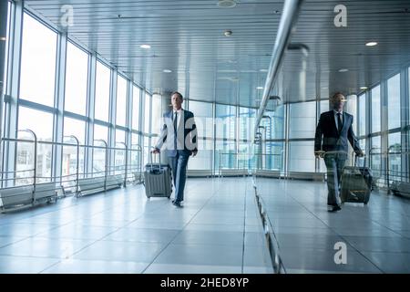 Male passenger with the baggage walking ahead Stock Photo
