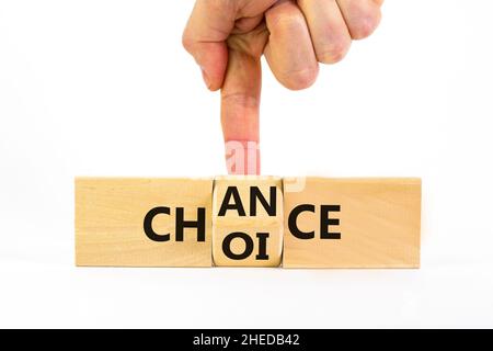 Choice and chance symbol. Businessman turns the wooden cube and changes the word choice to chance. Beautiful white table, white background, copy space Stock Photo