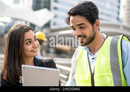 Engineers and executives are discussing plans in the construction site. Stock Photo