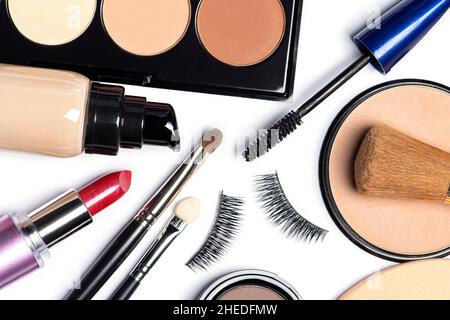 Foundation, powder, concealer, make up brushes, make-up sponges, false eyelashes, lipstick, mascara on white background Stock Photo