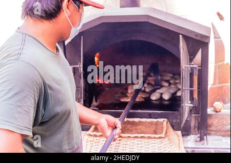 Daily production of bread baked with wood oven with traditional method Stock Photo