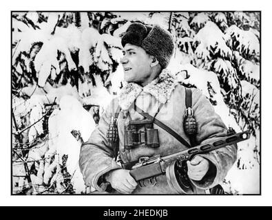 WW2 Great Patriotic Winter War 1941 Soviet Russian Soldier Pyotr Vasilievich during the Second World War in his winter uniform, with heavy snow behind, holding a Russian machine gun also armed with two grenades attached to his webbing. Battle of Moscow against Nazi Germany Occupation. WW2 World War II Stock Photo