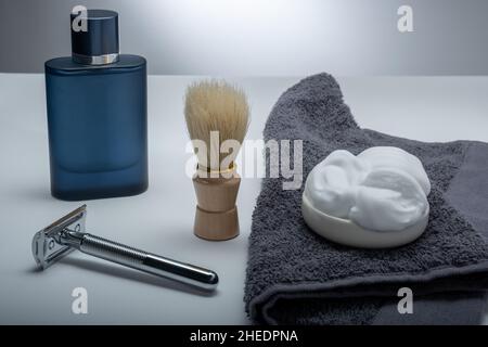 Helsinki / Finland - JANUARY 10, 2022: Closeup of men's toilet accessories: aftershave, a razor, a shaving brush, and some shaving foam. Stock Photo