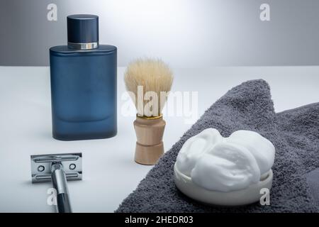 Helsinki / Finland - JANUARY 10, 2022: Closeup of men's toilet accessories: a razor, a shaving brush, and some shaving foam. Stock Photo