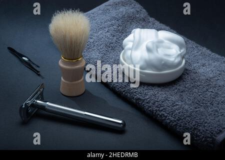 Helsinki / Finland - JANUARY 10, 2022: Closeup of men's toilet accessories: a razor, a shaving brush, and some shaving foam. Stock Photo