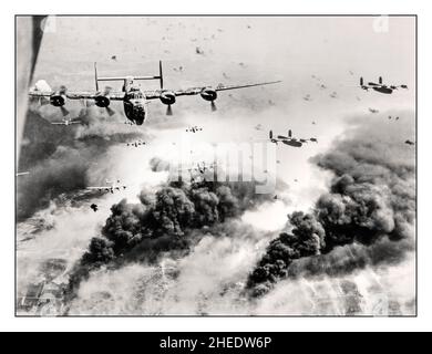 WW2 Bombing run heroic American Airforce B-24 Liberators flying through flak and over the destruction created by waves of bombers, 15th Air Force B-24s leave Ploieşti, Romania, after one of many attacks against the leading oil refinery target in continental Europe. (U.S. Air Force photo) LOC caption: 'Waves of Consolidated B-24 liberators of the 15th AAF fly over the target area, the Concordia Vega Oil refinery, Ploești, Romania, with bursting flak, after dropping their bomb loads on the oil plant,  31 May '44'  The  mission was deemed a success, though 54 of the 177 bombers didn't return Stock Photo