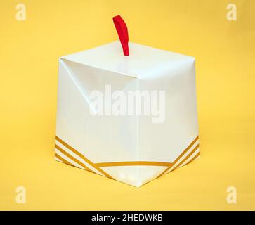 Closed white cardboard cake box isolated on yellow background Stock Photo