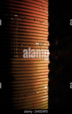 Red peeling paint on agricultural silos made of corrugated metal. Stock Photo