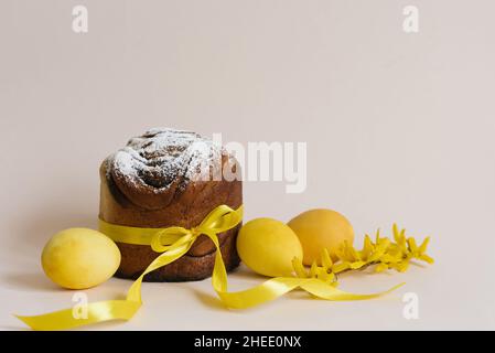 Set of traditional Russian and Ukrainian Easter cakes Kulich Paska bread sprinkled with powdered sugar whole, with yellow flowers, painted eggs, over Stock Photo