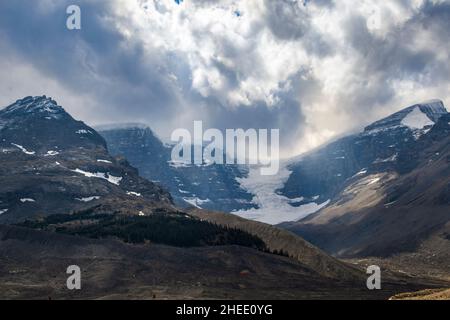 Stunning sun rays shining on the peaks and glaciers at Columbia Ice field, Alberta, Canada. Beautiful light coming from the dramatic sky. Stock Photo