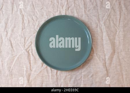 Green colored circle shaped ceramic plate on isolated background, food mockup Stock Photo