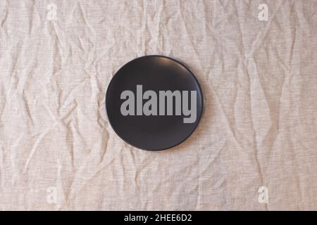 Dark colored circle shaped ceramic plate on isolated background, food mockup Stock Photo