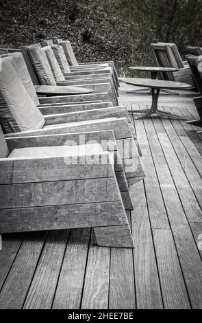 Modern Rustic rocking chairs lined up on Deck - Black and White - Focus on foreground. Stock Photo