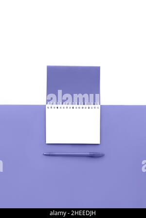 Top view of opened spiral notepad with pen toned in trendy color of year 2022 with isolated white page. Mockup for your design. Copy space. Stock Photo