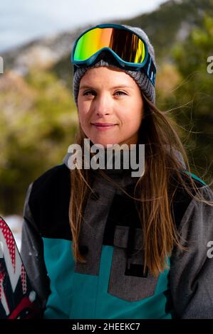Young positive Woman wearing warm sport suit and knitted hat and ski mask in winter day looking at camera Stock Photo