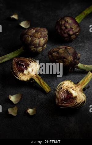 From above ripe green artichokes placed on black table background Stock Photo