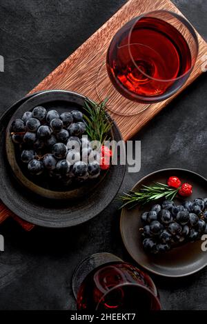 From above wine glass placed on table with fresh ripe grapes in studio on black background Stock Photo