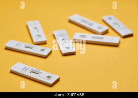 Yellow background with various covid negative rapid tests Stock Photo