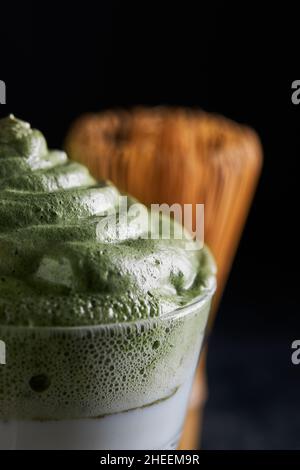Glass of fresh dalgona coffee with matcha and Japanese tea ceremony accessories consisting of bamboo whisk called chasen placed on gray surface Stock Photo