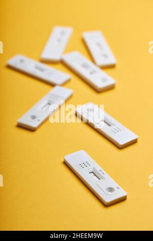 Yellow background with various covid negative rapid tests Stock Photo