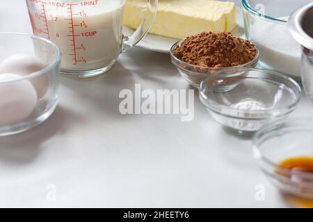 Various ingredients for baking arranged at the top of photo.  Copy space in lower half.  Ingredients include: eggs, milk, butter, cocoa, baking powder Stock Photo