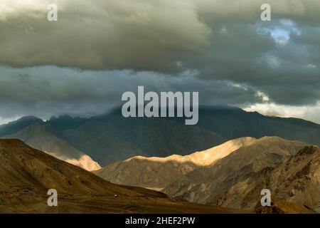 sun peaking through the clouds in the beautiful mountains of leh ladakh, India. Stock Photo