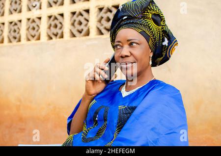 aged woman seating outdoor making calls Stock Photo