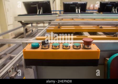 Control buttons installed at line conveyor for TV assembly line. Stock Photo