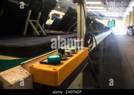 Control buttons installed at line conveyor for TV assembly line. Stock Photo