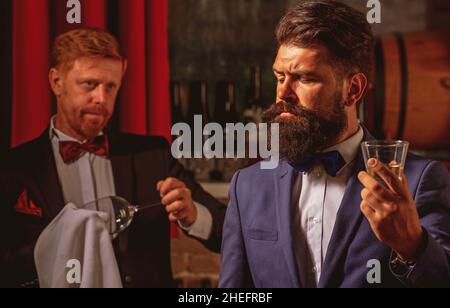 Barman at counter. Hipster in bar. Old traditional whiskey drink. Gentlemans beverage. Stock Photo