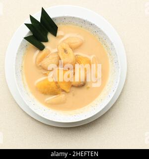 Kolak Pisang is Indonesian Traditional Dessert made of Sliced Banana and Sweet Potato with Palm Sugar Sauce with Pandan Leaf as Garnish. Selective Foc Stock Photo