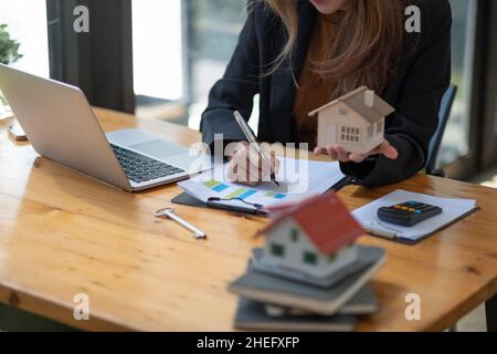 Business Financing Accounting Banking Concept, businesswoman doing finances and calculate about cost to real estate investment and tax Stock Photo