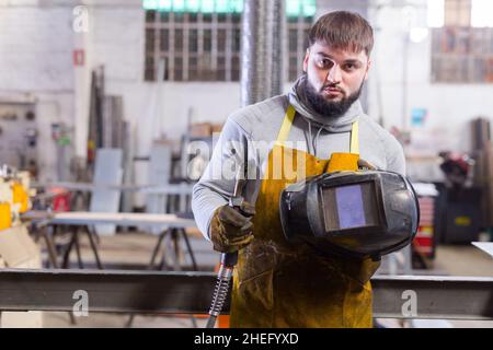 Man using welder for construction work at the workshop Stock Photo