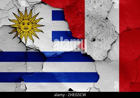 flags of Uruguay and Peru painted on cracked wall Stock Photo