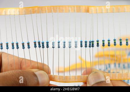 Pack of resistor which is an electronic component held in hand against the white background Stock Photo