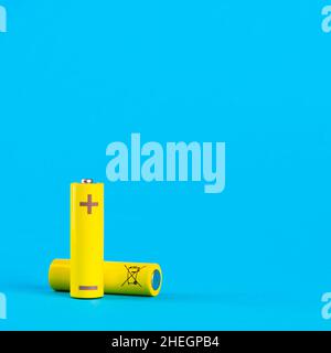 Two yellow AA alkaline batteries or NiMH rechargeable batteries on a blue background with space for text. Power elements on a blue background. Stock Photo