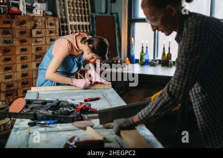 Man and woman working in workshop, doing furniture, reuse old materials to new product. awareness in consumption. Small family business. Recycling Stock Photo