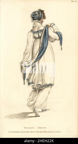 Walking dress: spotted muslin under-dress with a light coat bordered with cerulean blue. Blue silk headdress and scarf, bound with silver cords and tassels. York tan gloves. Plate 29, June 1809. Handcoloured copperplate engraving by Thomas Uwins from Rudolph Ackermann's Repository of Arts, London. Stock Photo